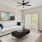 a living room with a white couch and a fan